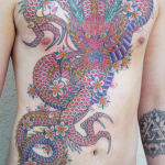 Large, brightly coloured Dragon and Cherry Blossoms tattoo, filling a mans front. Tattooed by Aaron Hewitt at Cult Classic Tattoo in Romford, Essex. Just outside of London.